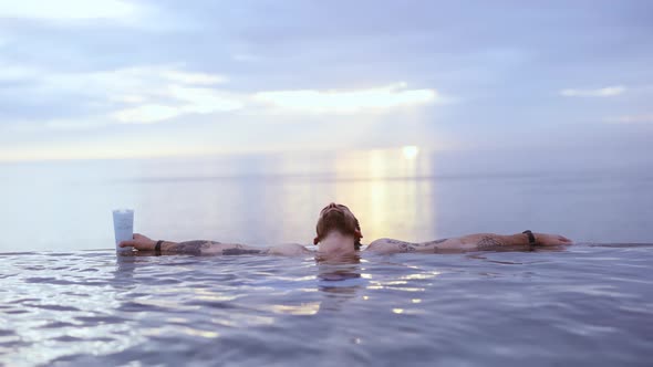 Male Model Resting His Head at the Edge of the Infinity Pool