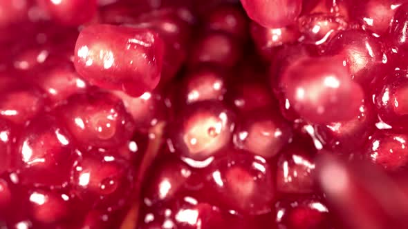 Pomegranate Grains Rolls Down on Surface of Broken Pomegranate in Slow Motion