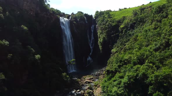 Drone shot of Mpumalanga in South Africa - drone is reversing from a waterfall in a natural valley.