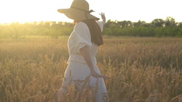 Young Girl Running in Slow Motion Through a Wheat Field