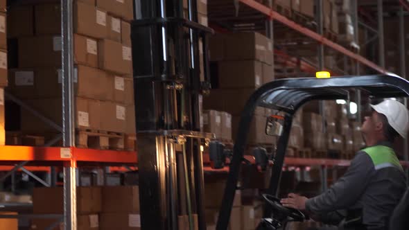 Warehouse Worker on Forklift Placing Load on Shelf