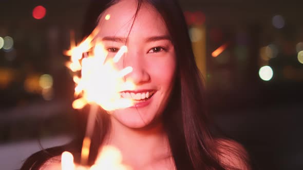 Young asian woman with sparklers is dancing and celebrating a new year.