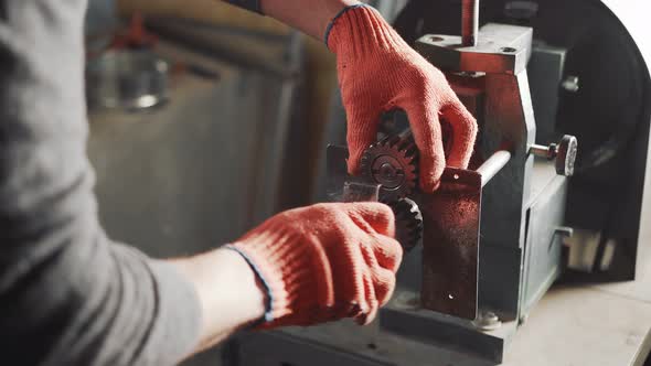 Close-up of a Locksmith Working with a Metalworking Machine Repairing a Machine and Clamping Gear