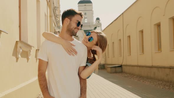 Portrait of smiling beautiful female and her handsome boyfriend posing outdoors