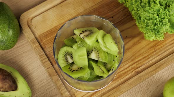 Closeup Top View Tossing Thinly Sliced Kiwi Slices Into Blender