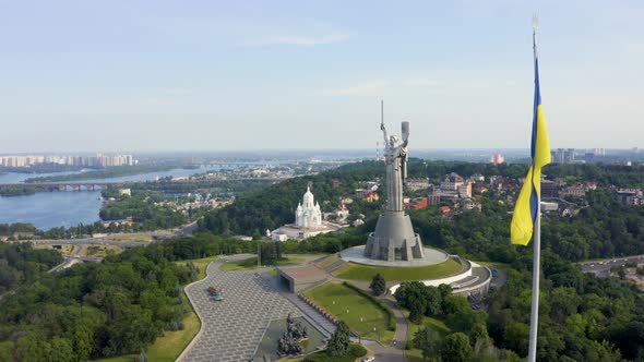 Aerial View of the Ukrainian Flag Waving in the Wind Against the City of Kyiv