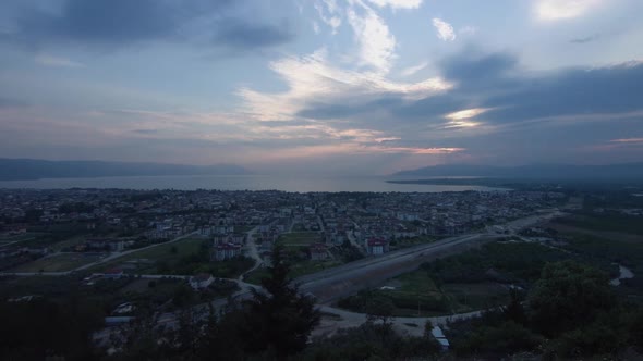 Sunset and city at sea. Time lapse.