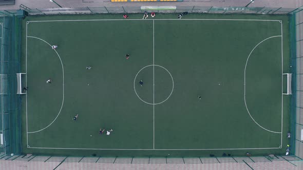 Players Play Football on a Green Football Field with White Markings