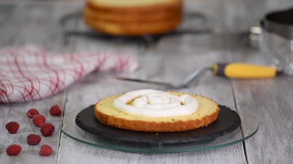 Close-up of pastry covered with butter cream sponge cake. Cream in a pastry bag