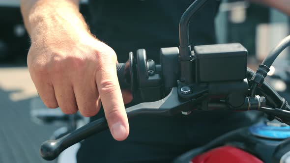 Male Hand on the Throttle of a Motorcycle Without a Glove