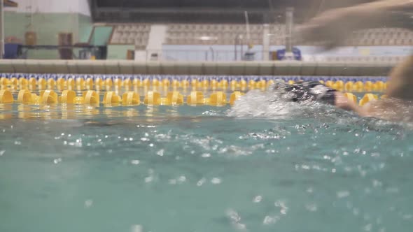 Professional Swimmer Trains by Freestyle in Swimming Pool and Take a Deep Breath
