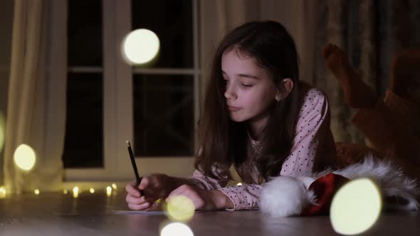 Christmas Moment. A Charming Little Girl Is Writing a Letter To Santa Claus.