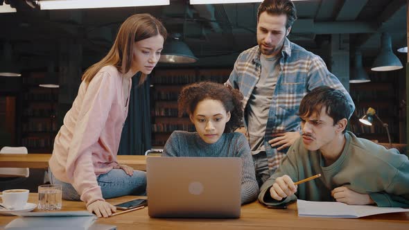 Thoughtful Young Multiethnic Team Deal with Difficult Problem Before Laptop