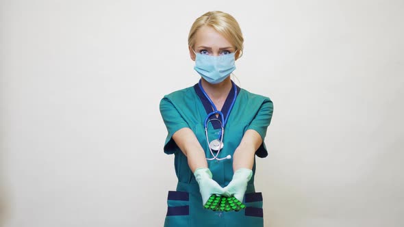 Medical Doctor Nurse Woman Wearing Protective Mask and Rubber or Latex Gloves - Holding Pills