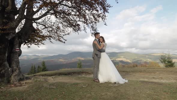 Lovely Young Newlyweds Bride Groom Embracing on Mountain Autumn Slope Wedding Couple Family in Love