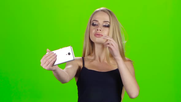 On the Smartphone Camera Blonde Girl Doing Selfie. Green Screen