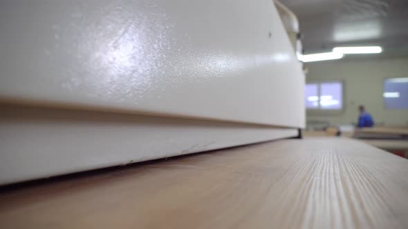 Close-up of a part of a wooden part on an edge-banding machine