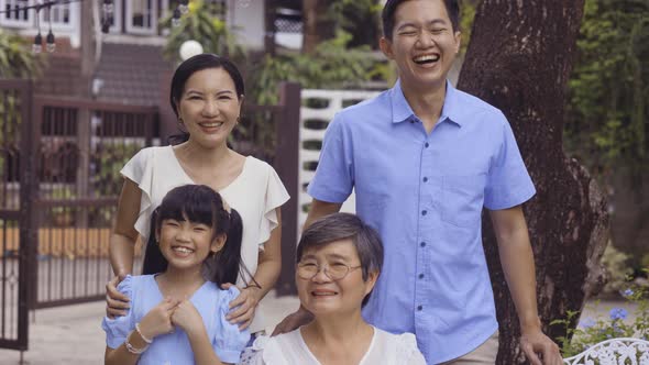 Asian Multi Generational Family Looking at Camera and Smiling at Home