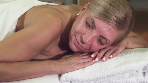 Relaxed Woman Lies on a Massage Table