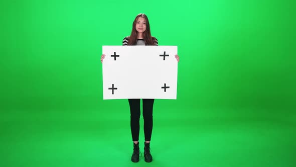 Protest Movement Female Activist Standing on the Green Background and Holds a White Paper Poster