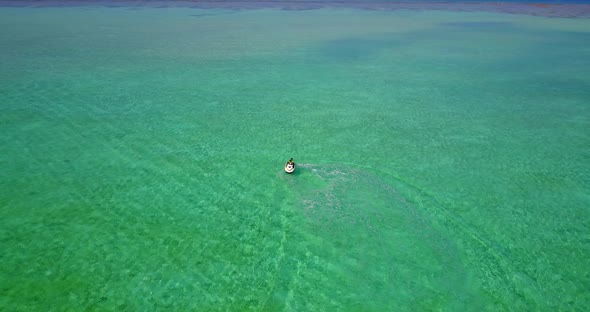 Natural above island view of a paradise sunny white sand beach and blue sea background in 4K