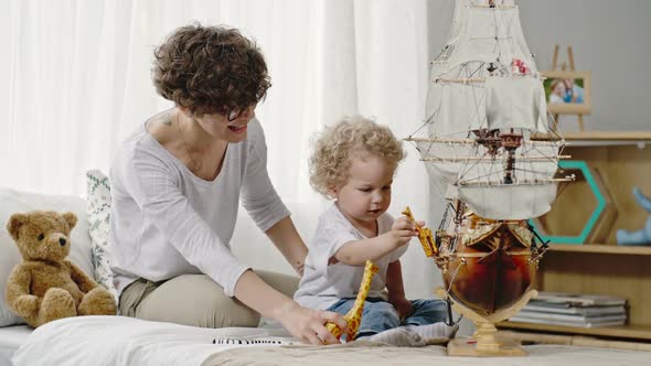 Laughing Mother and Toddler Boy  Playing with Toys