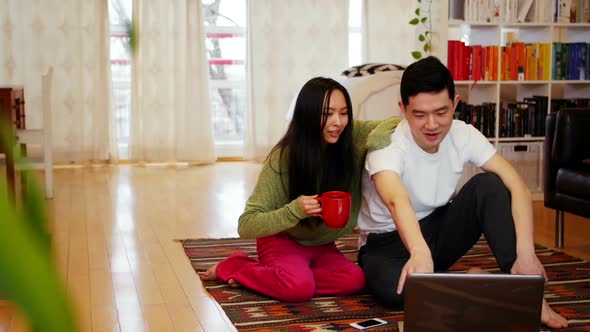 Couple using laptop in living room