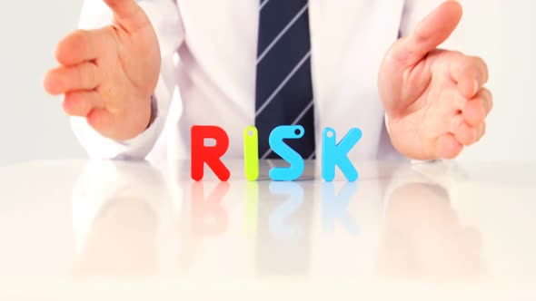 Businessman showing the word risk with alphabet