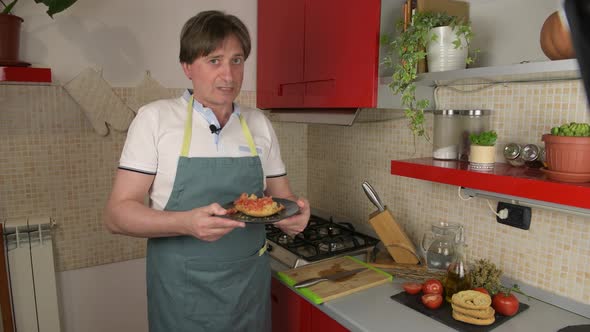 A man video blogger prepare a typical dish of Puglia friselle