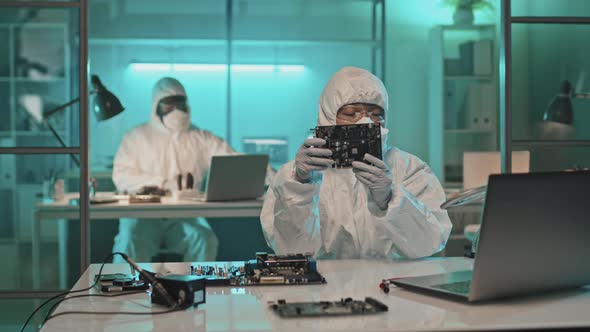 Engineer in Coveralls Working with Computer components in Lab