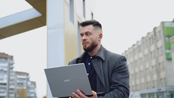 Young businessman with laptop. Businessman freelancer working on computer in city