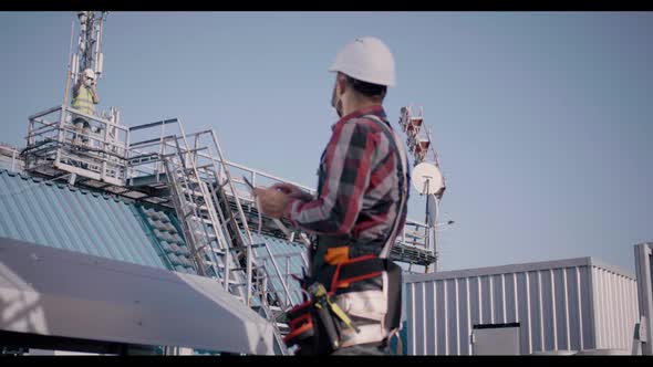 Engineer Using Tablet on a Cellular Tower