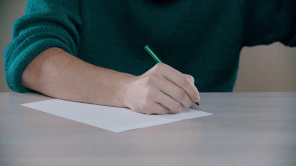 A Man Is Actively Writing Word on a Paper