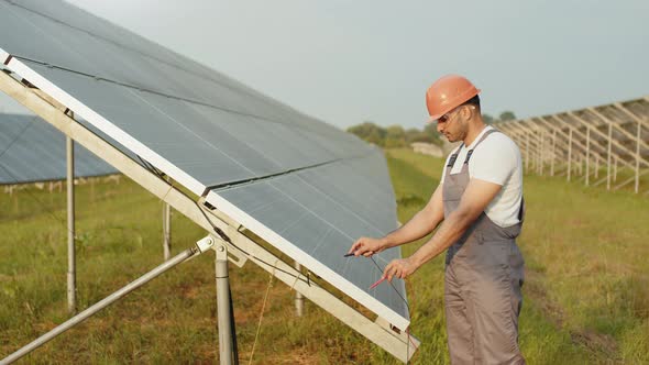 Professional Energy Technician Measuring Voltage in Solar Cells at Outdoors