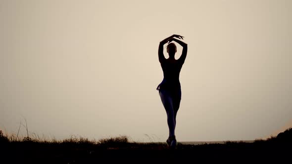 the Silhouette of a Woman at Sunset Dancing Gracefully Ballet