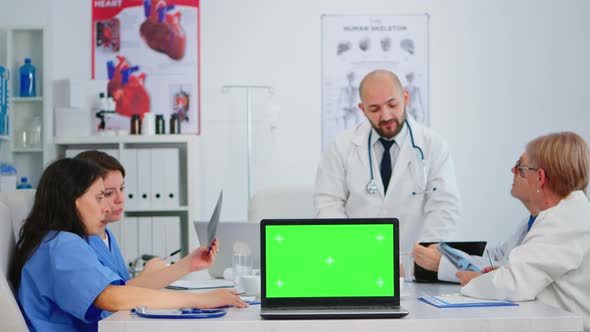 Medical Colleagues Working in Hospital Office Using Laptop with Mockup Display