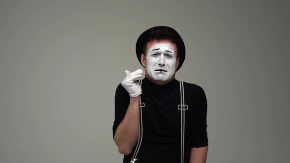 Portrait of Suffering Male Mime Experiences Severe Pain in Teeth and Touches Face with Hand