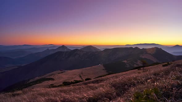 Mountain landscape at sunrise, mountain meadow, grass ripples in the wind , clear sky