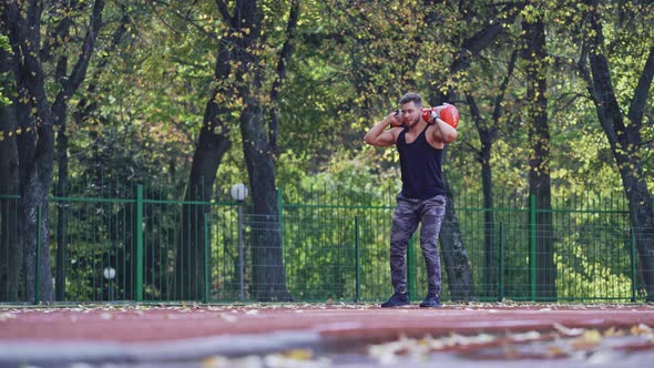 Sportsman during workout at stadium. Man doing exercises during workout at stadium