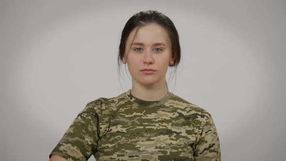 Portrait of Serious Confident Female Soldier Saluting Looking at Camera