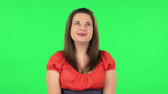 Portrait of Cute Girl Is Daydreaming and Smiling Looking Up. Green Screen