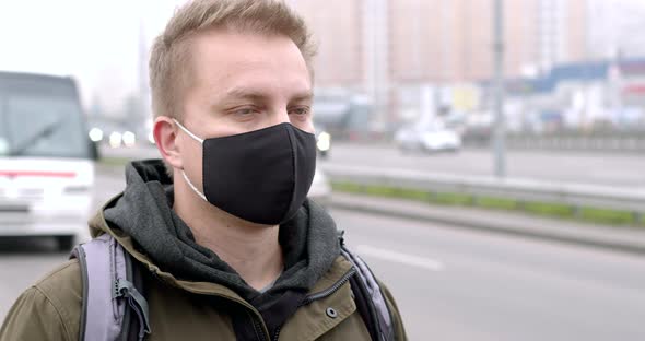 Portrait of a man in a protective mask standing on a city street