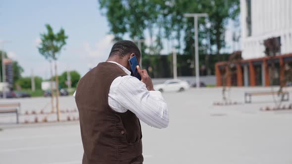 Young african businessman talking on the mobile phone with business clients