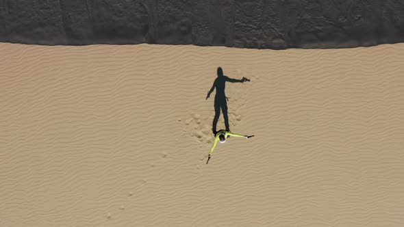 Excited Young Gamer Girl Staying on Sand Dune in Desert Playing Shooting Game