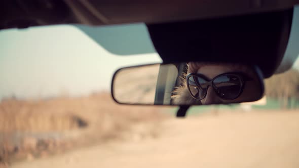 Woman Traveling On Automobile And Looking On Rearview Mirror. Woman Traveler Riding On Trip Holiday.