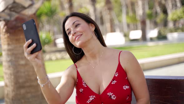 Smiling Woman with Smartphone on Street