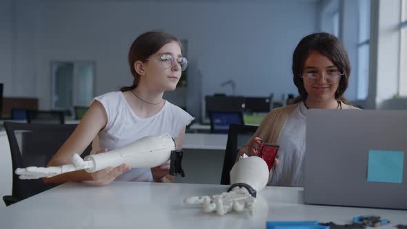 Girls Look the the Laptop's Screen and Connect the 3D Printed Hand