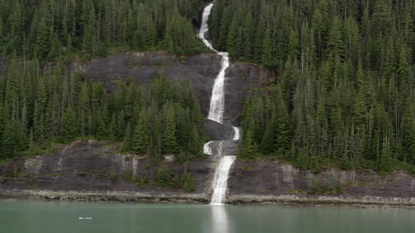 Panning view of waterfall flowing into ocean