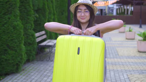 Portrait of a Smiling Asian Girl Traveler with a Suitcase in His Hand Slow Mo