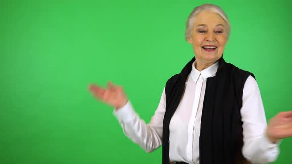 An elderly woman dances with a smile - green screen studio